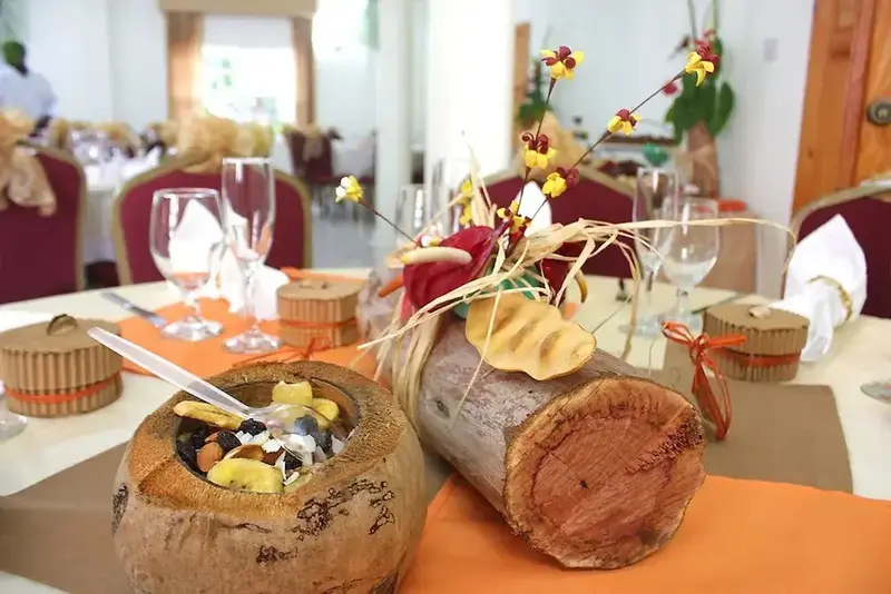 Une table dressée avec des plats colorés et une décoration florale exotique.