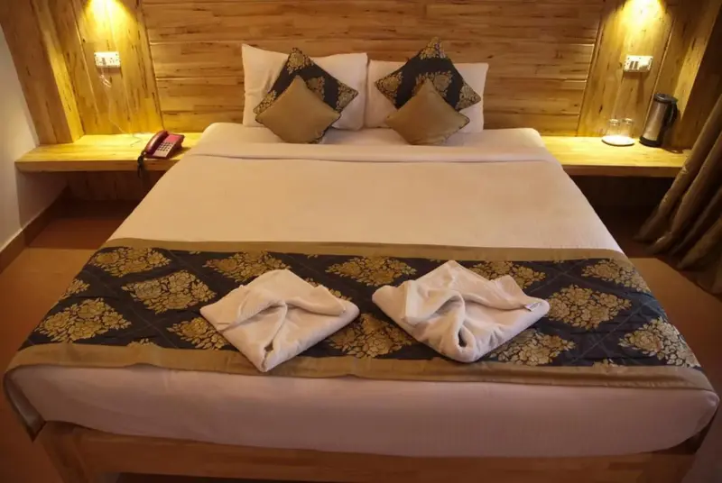 Une chambre lumineuse avec un grand lit décoré de coussins.