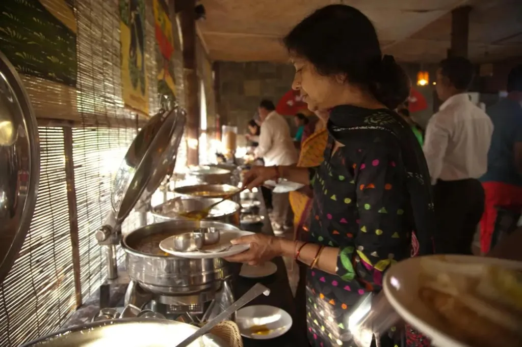 Une femme se sert des plats dans un buffet.