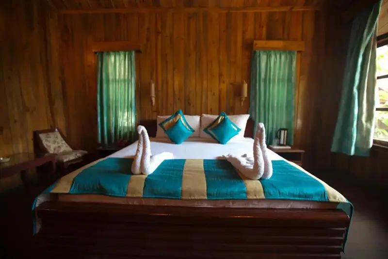 Une chambre avec un grand lit décoré de serviettes en forme de cygnes.