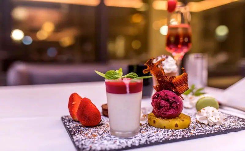 Assortiment de desserts colorés présentés sur une ardoise.