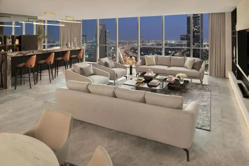 Un espace de vie moderne avec canapés, tables basses et un bar.