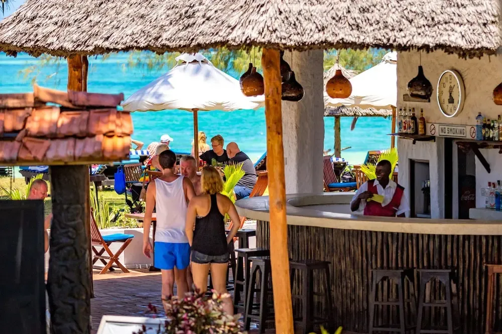 Un bar en bord de mer avec des clients et un serveur.