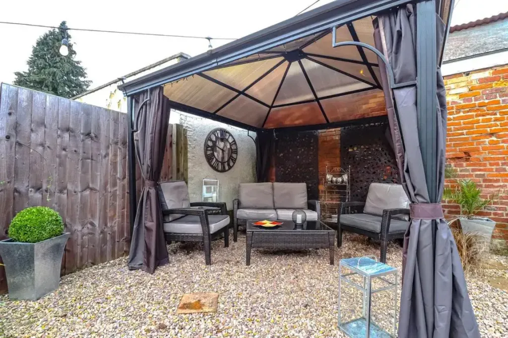 Espace de détente extérieur avec mobilier de jardin et décoration murale.