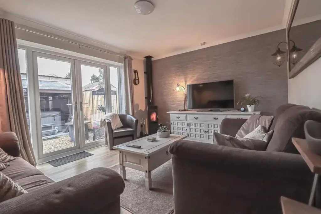 Un salon chaleureux avec canapés confortables et accès à une terrasse.