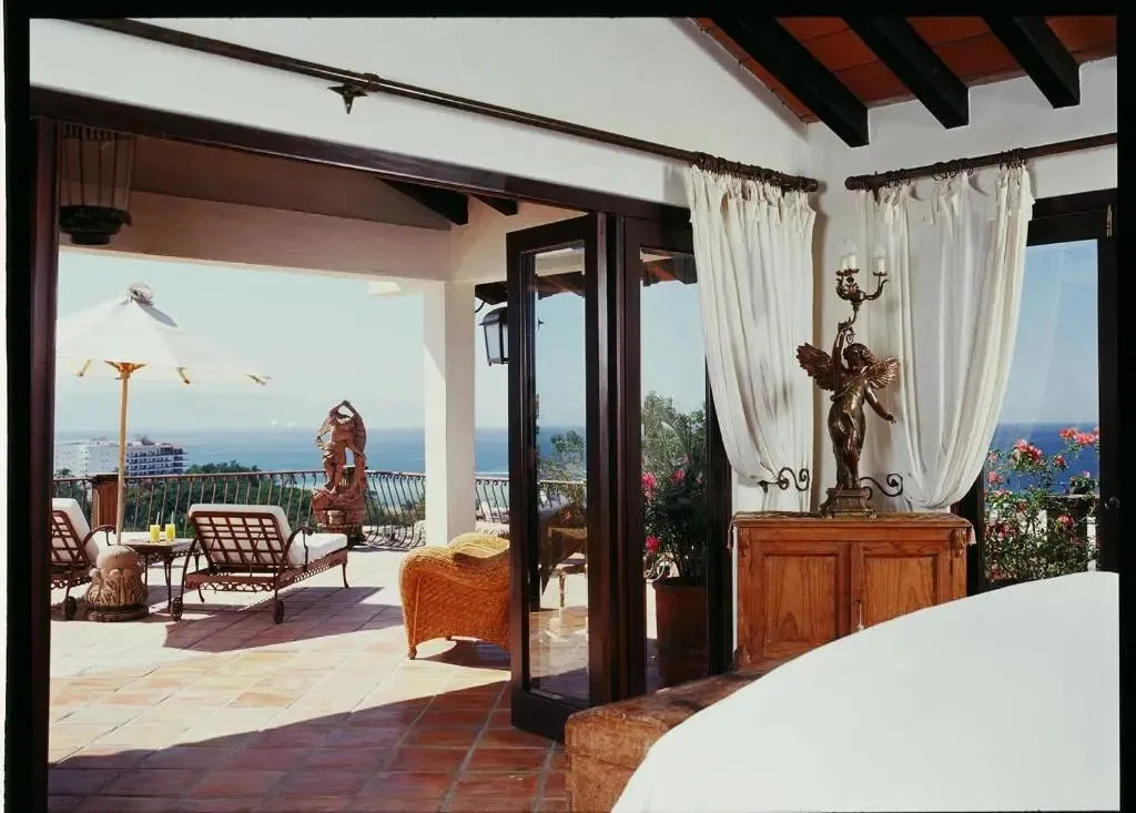Terrasse carrelée avec mobilier d'extérieur et vue sur la mer.