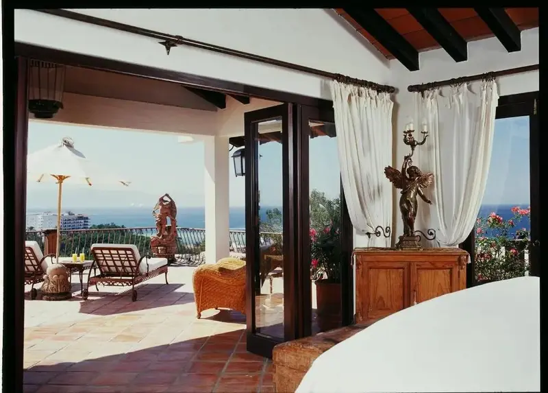 Terrasse carrelée avec mobilier d'extérieur et vue sur la mer.