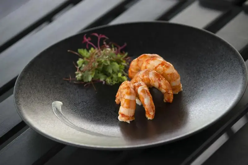 Assiette de crevettes décorée de verdure.