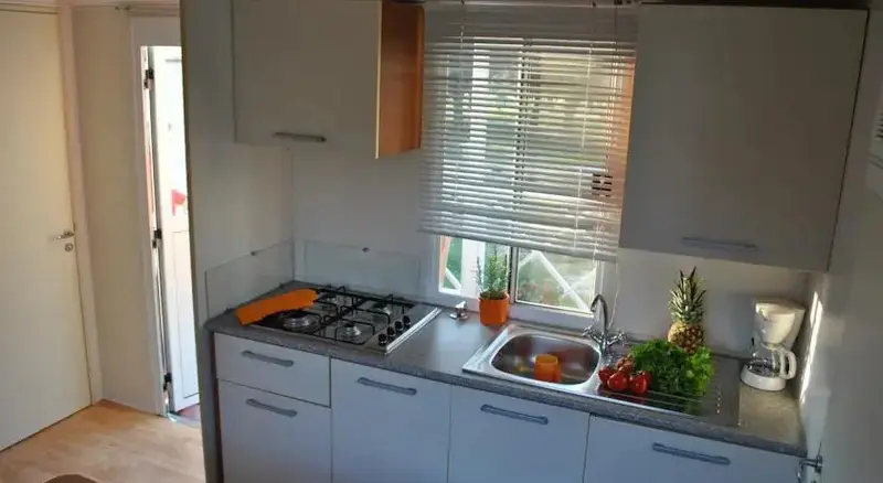 Une cuisine équipée avec un plan de travail et une fenêtre.