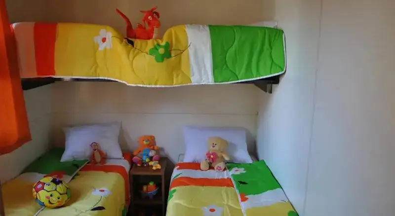 Une chambre avec des lits superposés et des peluches.