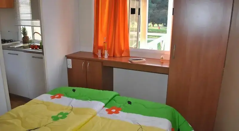 Une chambre lumineuse avec un bureau et une kitchenette.