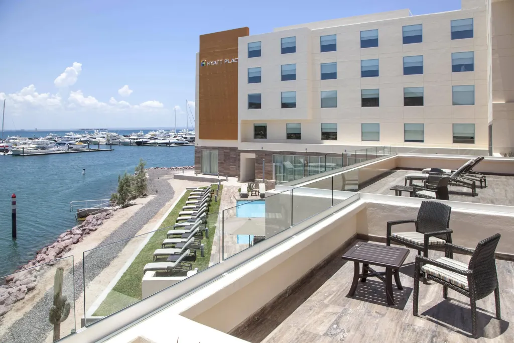 Terrasse avec mobilier de jardin et piscine au bord de l'eau.