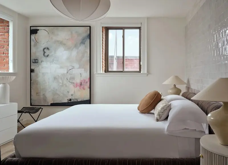 Une chambre lumineuse avec un grand lit et une décoration sobre.