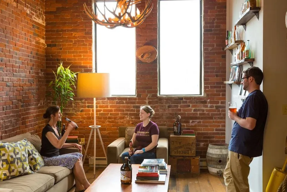 Un espace de détente intérieur avec des canapés et une table basse devant un mur de briques.