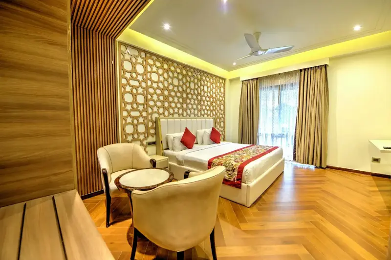 Une chambre lumineuse avec un grand lit et un coin salon.