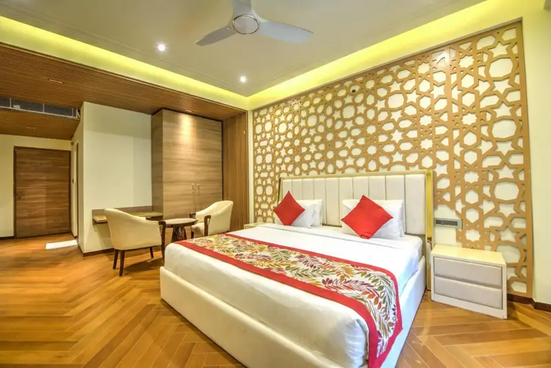 Une chambre lumineuse avec un grand lit et un coin salon.