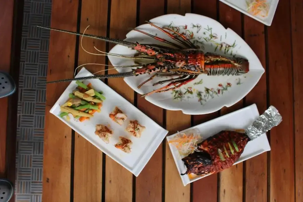 Assiettes de fruits de mer et de légumes présentées sur une table en bois.