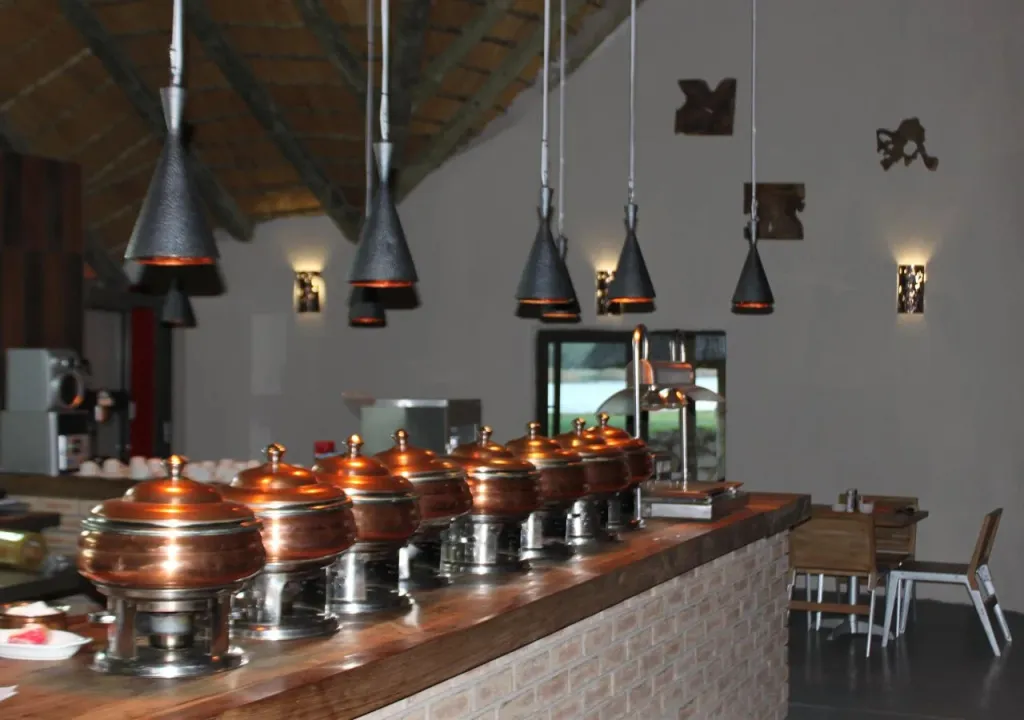 Un buffet propose une variété de plats chauds dans un espace lumineux et moderne.