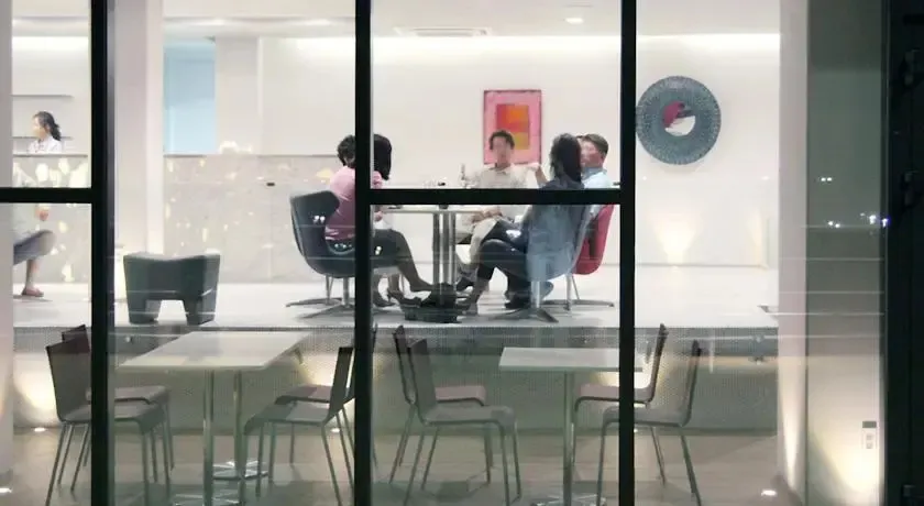 Des personnes sont assises autour d'une table dans un espace lumineux et moderne.