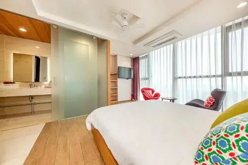 Une chambre lumineuse avec un grand lit et un accès à une salle de bain moderne.