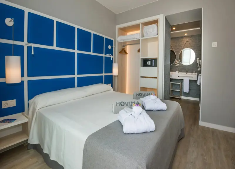 Une chambre lumineuse avec un grand lit et un accès à une salle de bain moderne.