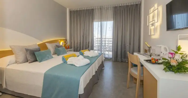 Une chambre lumineuse avec un grand lit et un espace bureau.
