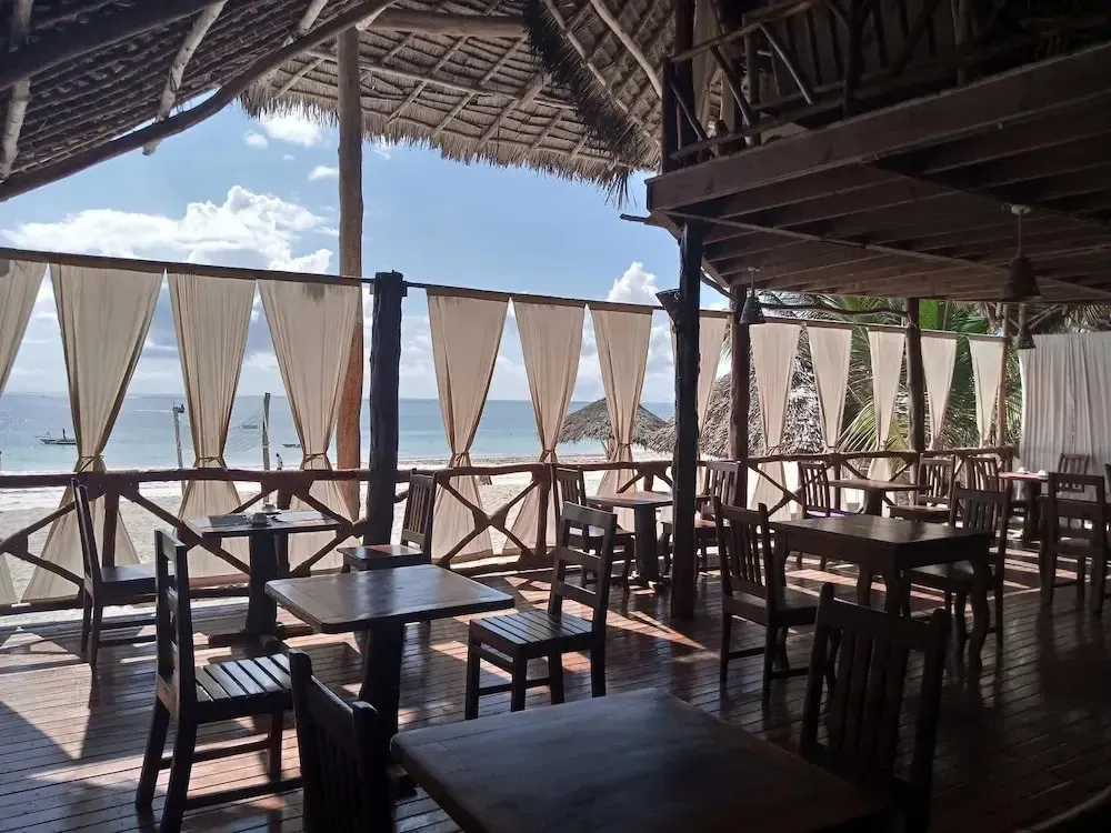 Une salle à manger en plein air offre une vue sur la plage et la mer.