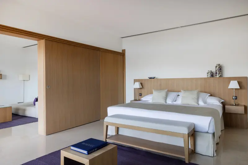 Une chambre lumineuse avec un grand lit et un espace détente.