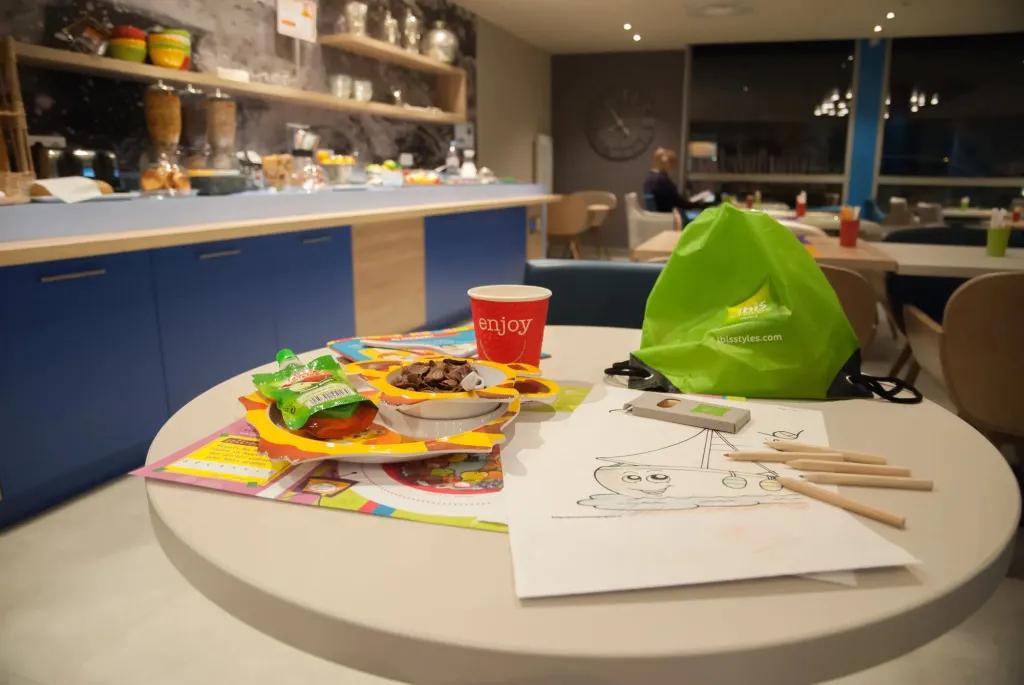 Une table ronde présente des collations, une boisson et du matériel de dessin.