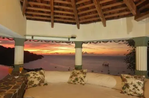 Un espace de détente extérieur offre une vue sur la mer au coucher du soleil.