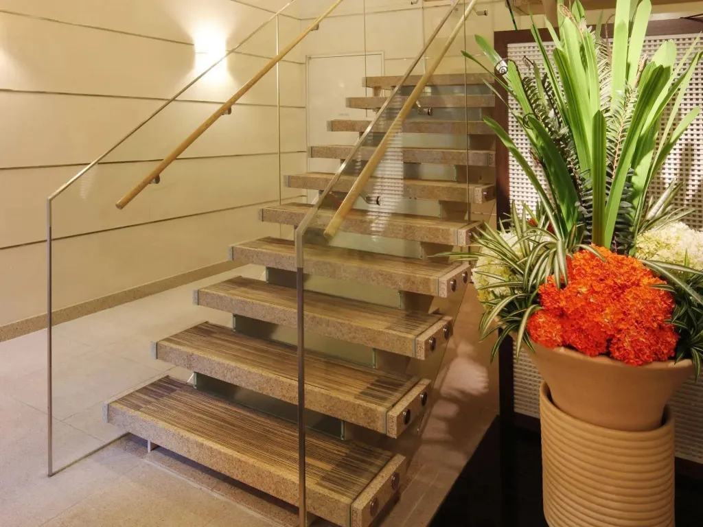 Escalier moderne en pierre et verre, agrémenté de plantes en pot.