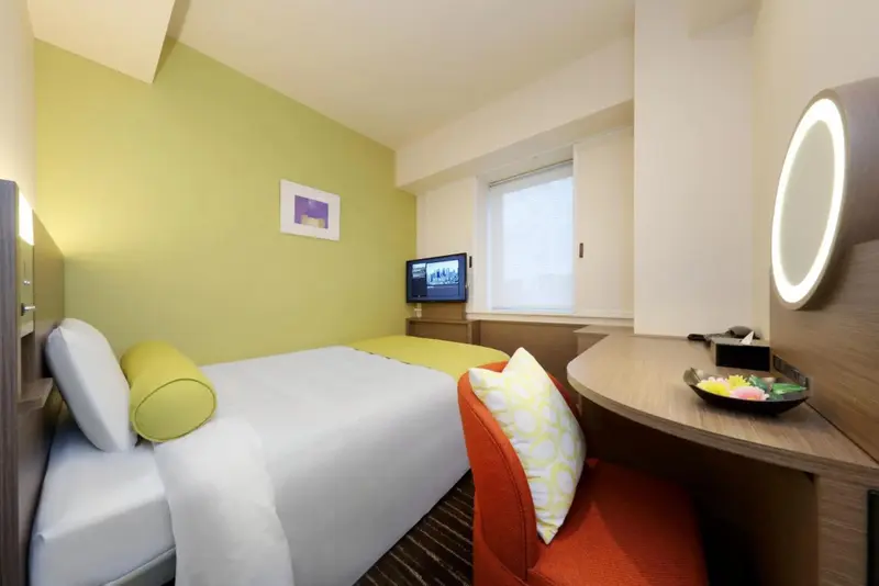 Une chambre lumineuse avec un lit simple et un bureau.