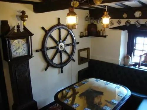 Une salle décorée avec un gouvernail de bateau et une horloge ancienne.