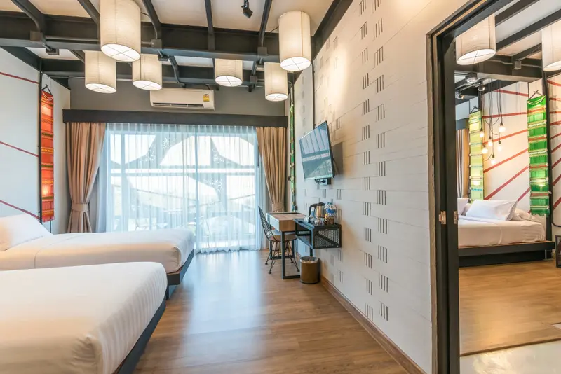 Une chambre lumineuse avec deux lits et une vue sur l'extérieur.