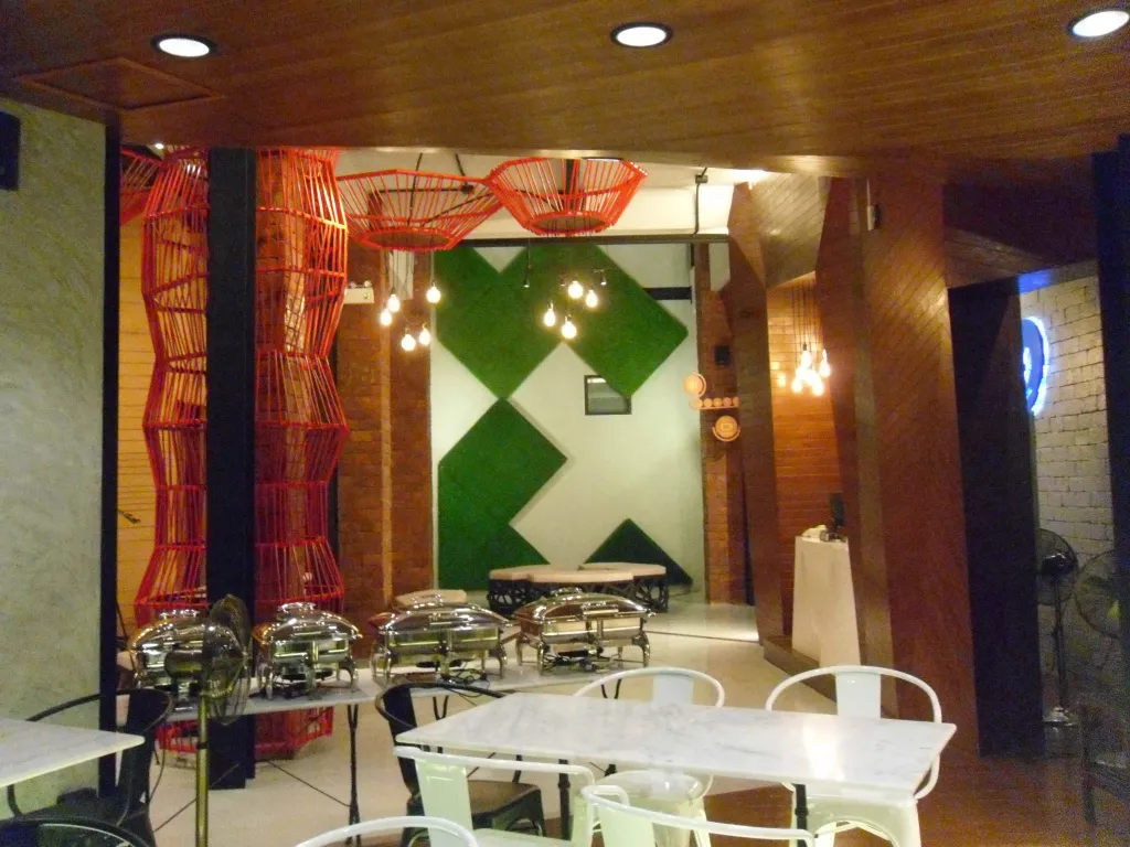 Une salle lumineuse avec des tables et des buffets de plats chauds.