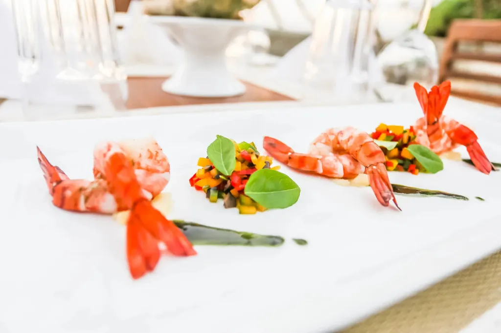 Présentation raffinée de crevettes sur une assiette blanche.