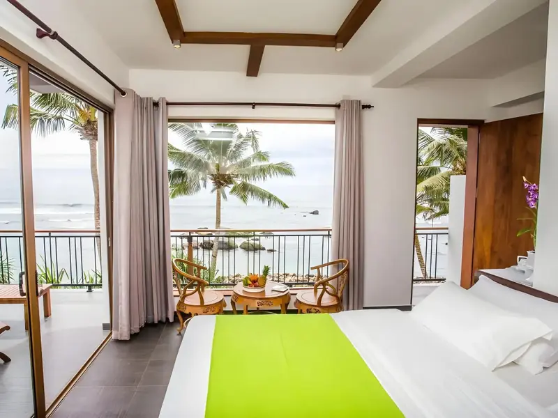Chambre lumineuse avec vue sur la mer et un balcon.