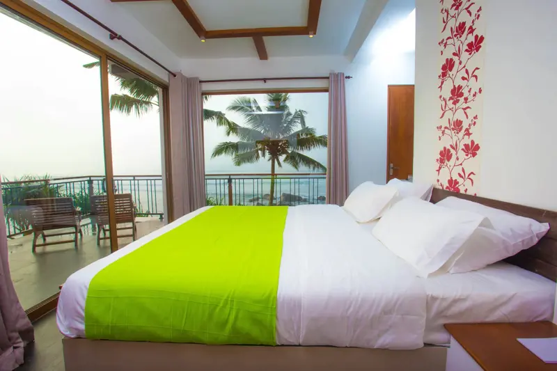 Une chambre lumineuse avec un grand lit donnant sur une vue mer.