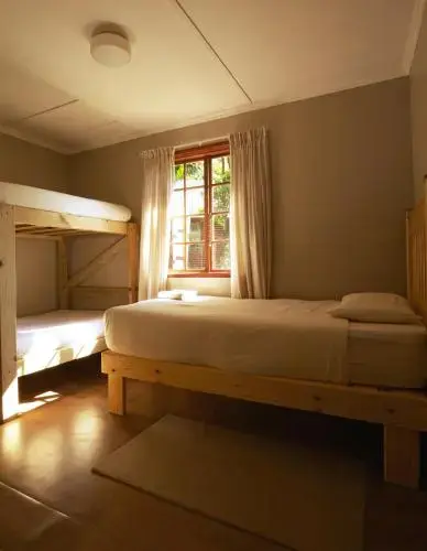 Une chambre lumineuse avec des lits simples et une fenêtre.