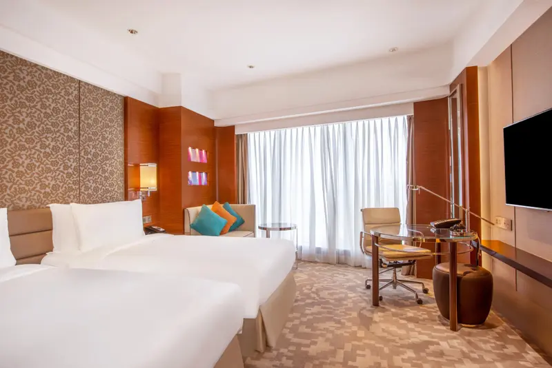 Une chambre lumineuse avec un grand lit et un espace bureau.