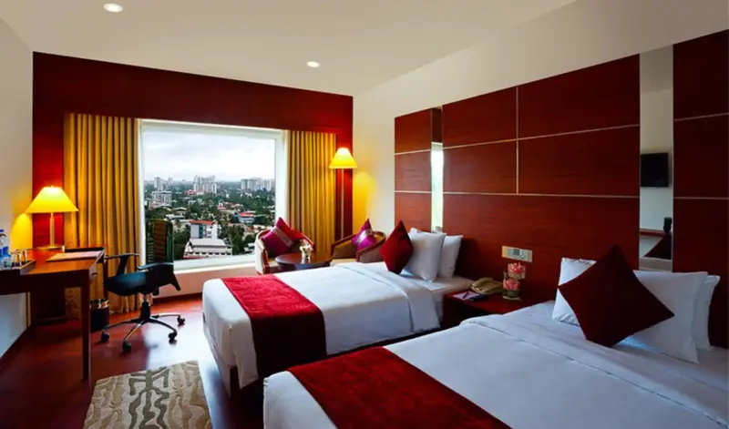 Chambre d'hôtel avec deux lits simples et une vue sur la ville.