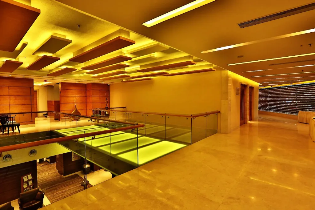 Espace intérieur lumineux avec mezzanine et garde-corps en verre.