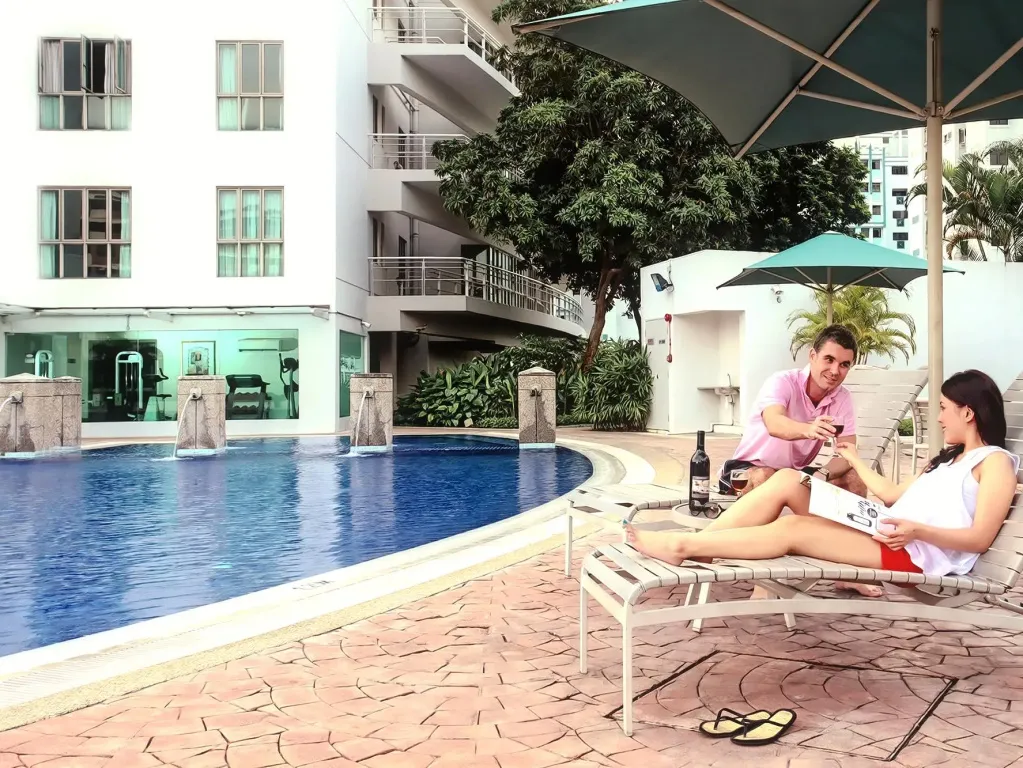 Un couple se détend au bord d'une piscine ensoleillée.