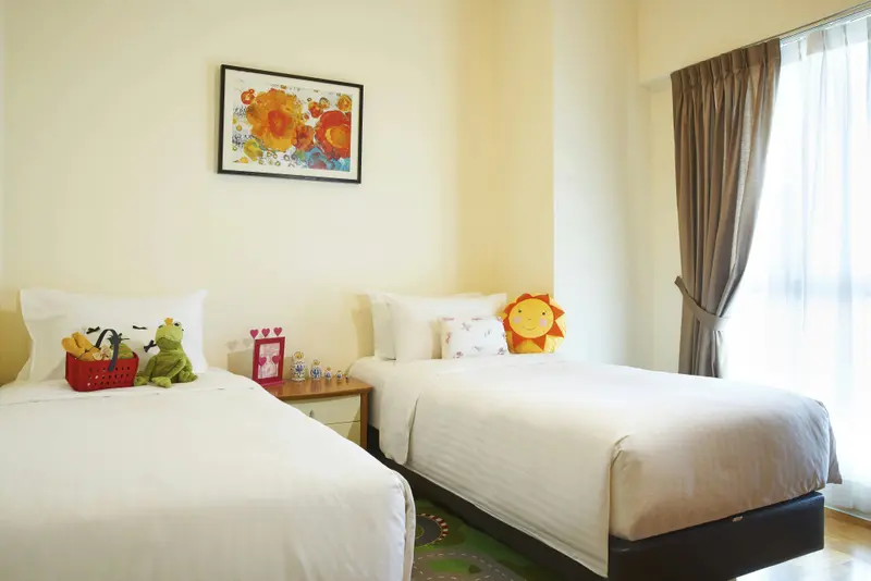Deux lits simples dans une chambre lumineuse avec une décoration colorée.