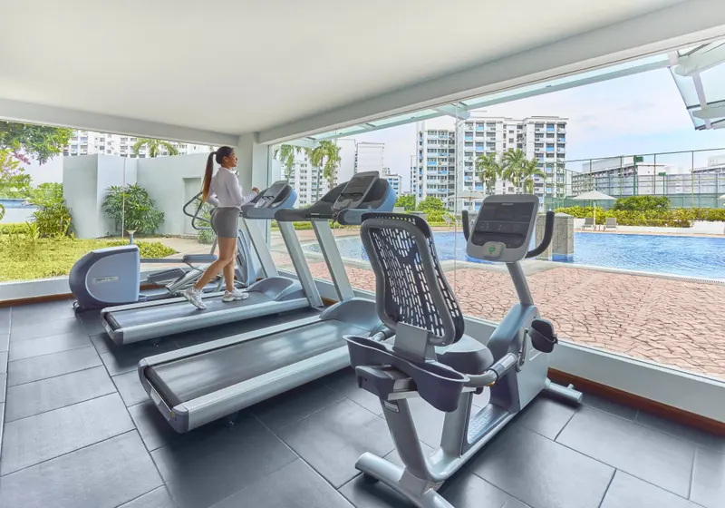 Une salle de sport lumineuse avec des tapis de course et des vélos d'appartement.