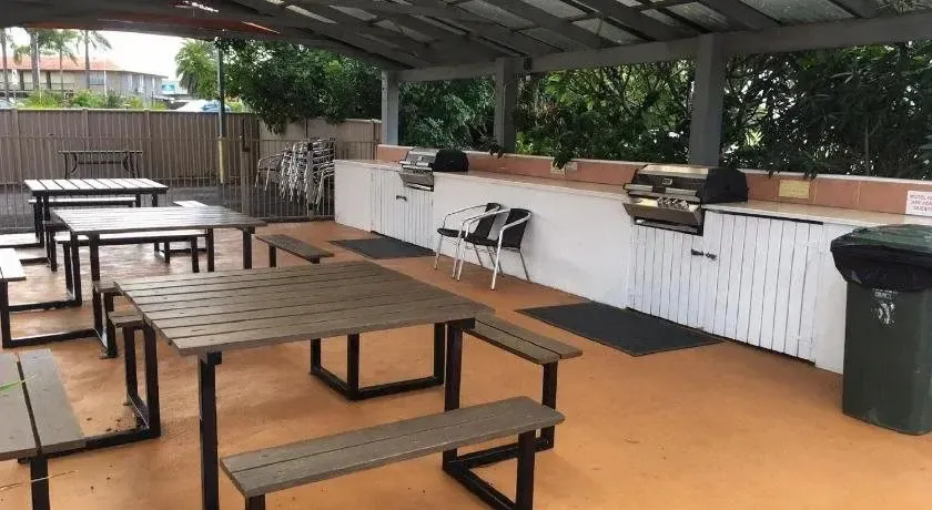 Espace extérieur aménagé avec des tables et des barbecues.
