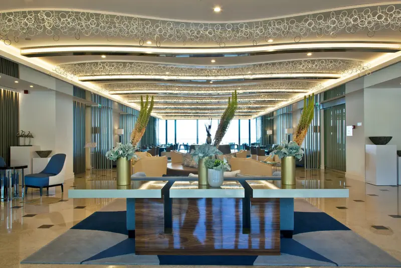 Un hall d'accueil lumineux avec un mobilier contemporain et des plantes.