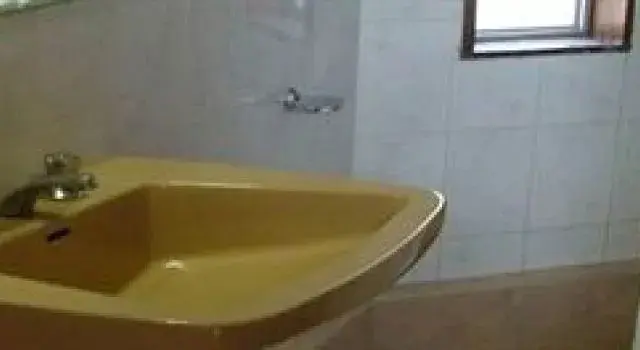 Une baignoire d'angle dans une salle de bain carrelée.