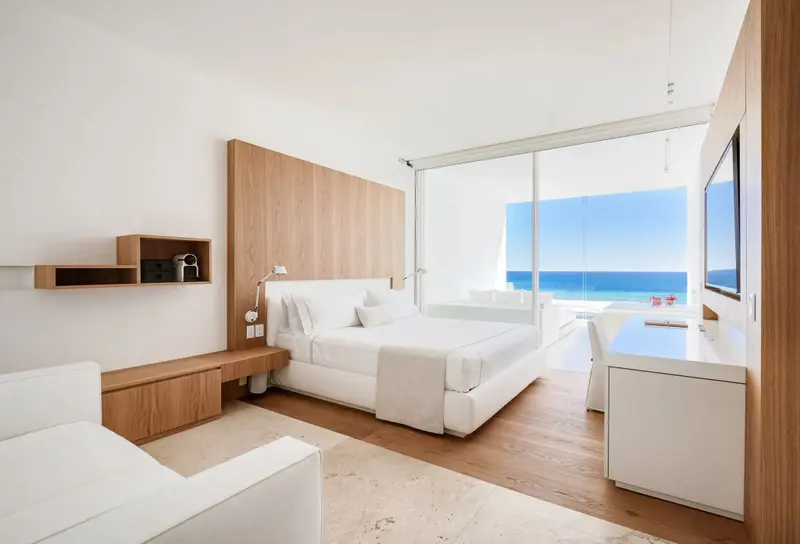 Une chambre lumineuse avec un grand lit face à l'océan.