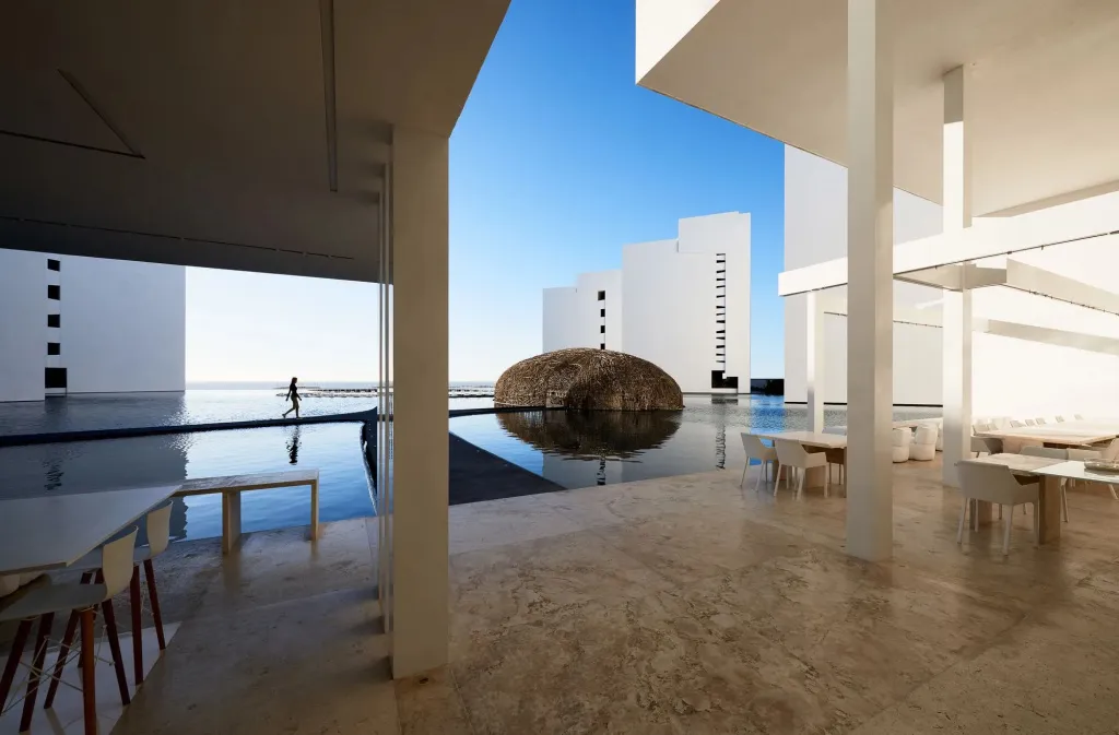 Espace architectural lumineux avec une piscine et des espaces de repos.